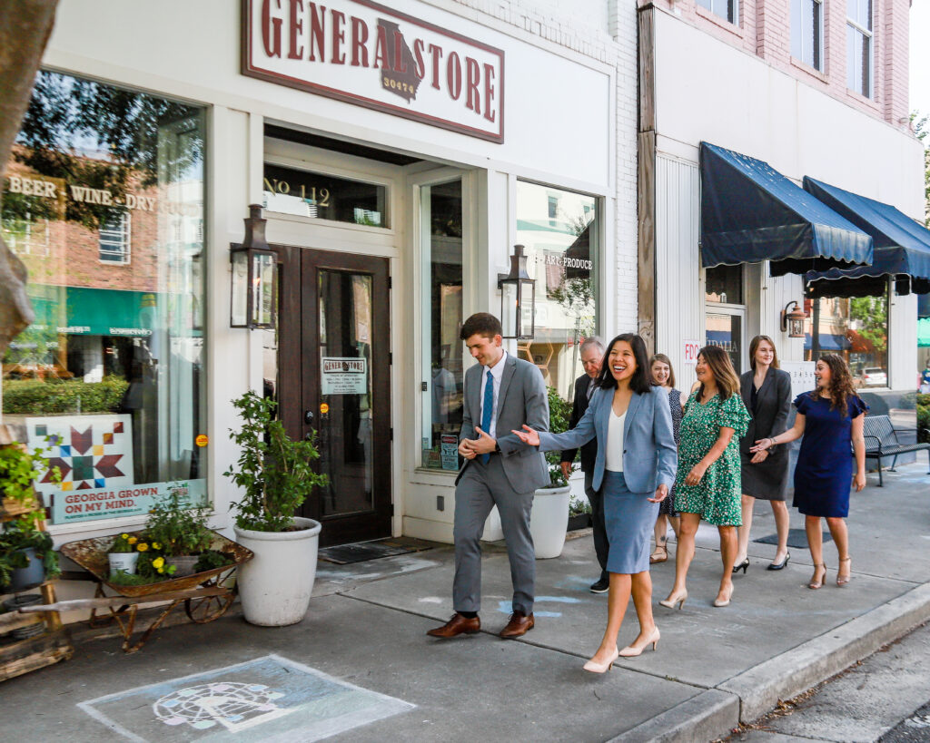 Business professionals walking through a downtown commercial district, showcasing community development, local business engagement, and professional branding photography.