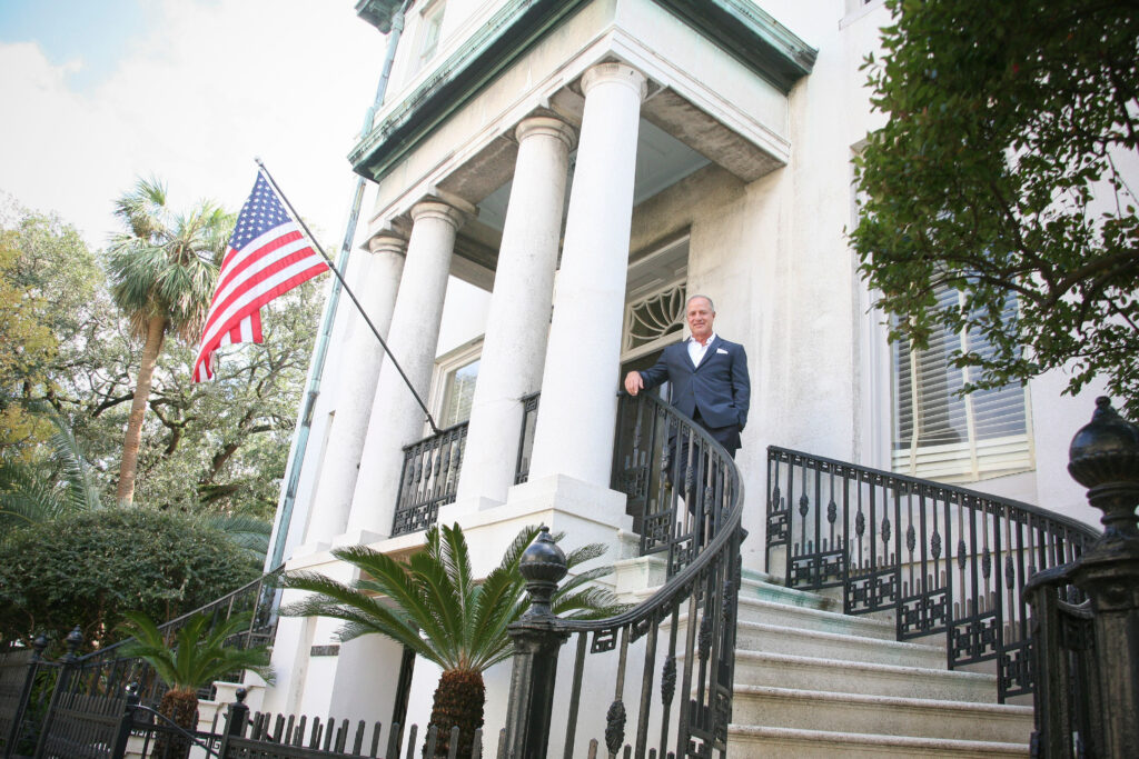 Professional environmental portrait of a business leader standing outside a historic property in Georgia.