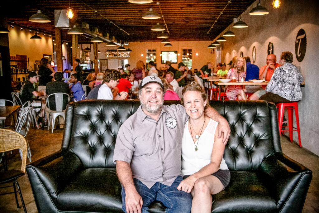 Local business owners seated inside a busy restaurant, showcasing community-focused branding photography and small business marketing services.