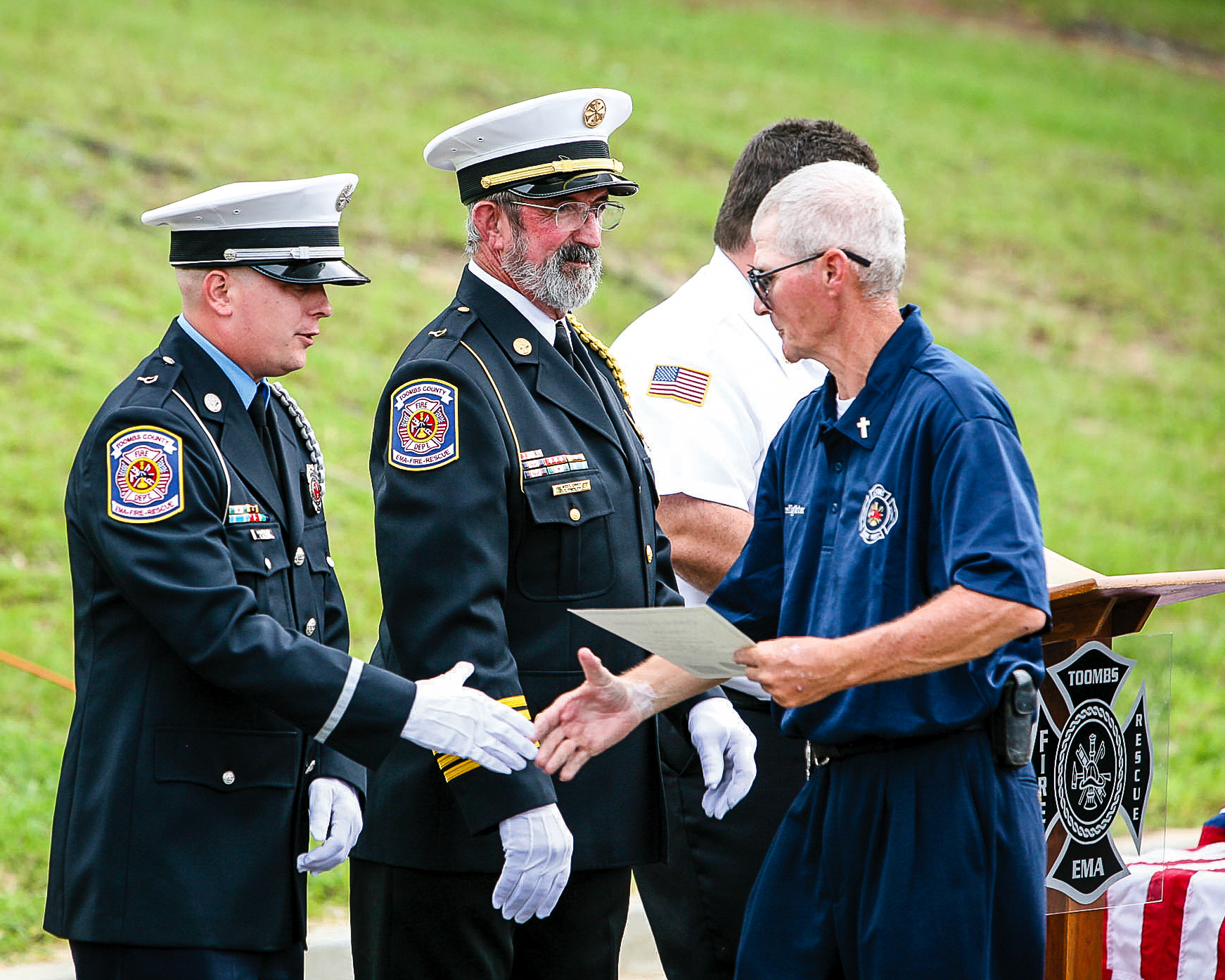 Firefighters participating in a recognition ceremony, photographed during a public safety and community event.