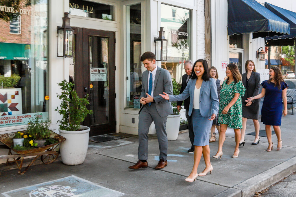 Business and community leaders walking through a historic downtown district, representing collaboration, economic development, and community engagement.